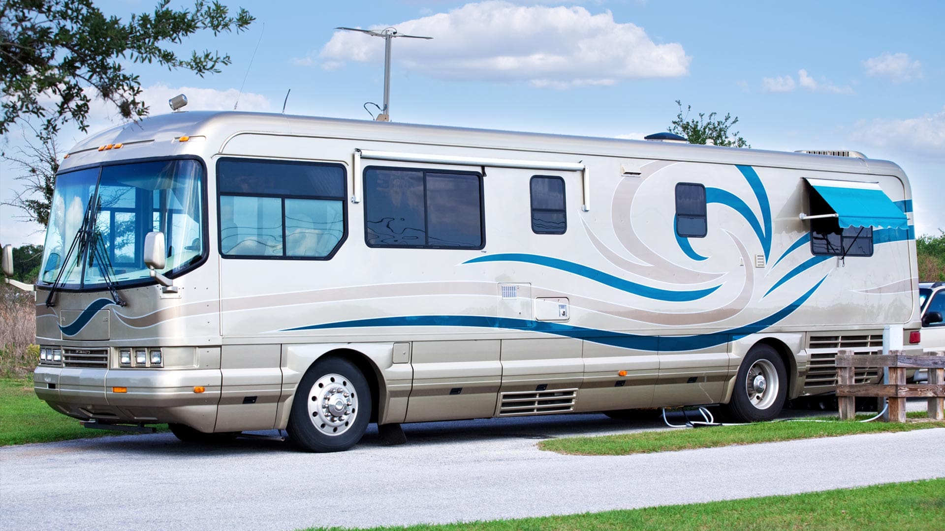 A white and blue rv parked on the side of a road.